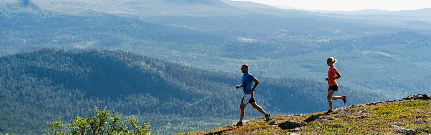 Två personer springer på fjället