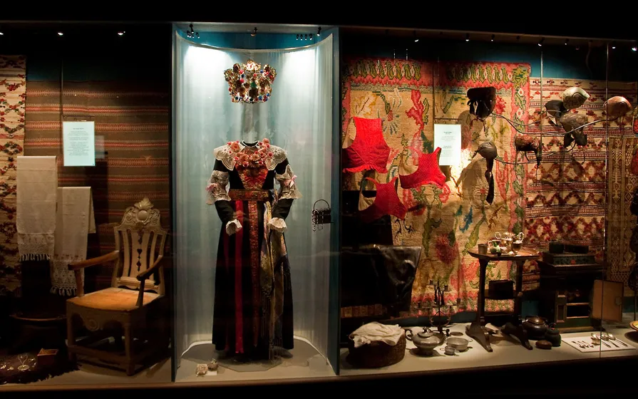 Äldre dräkter och föremål i museets utställning.