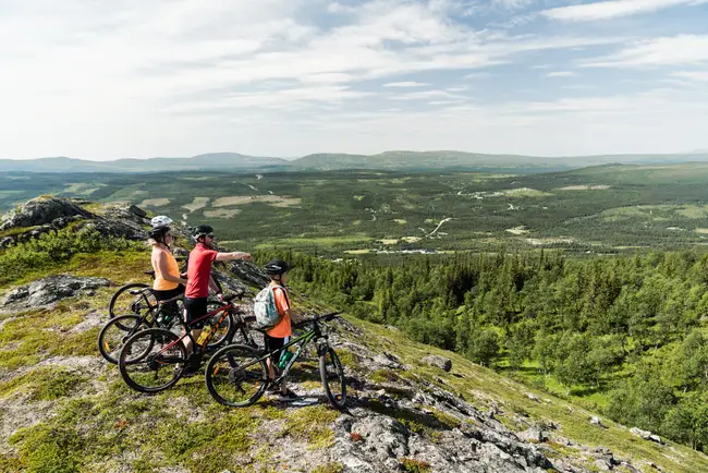 Familj blickar ut på fjällen på sina mtb-cyklar