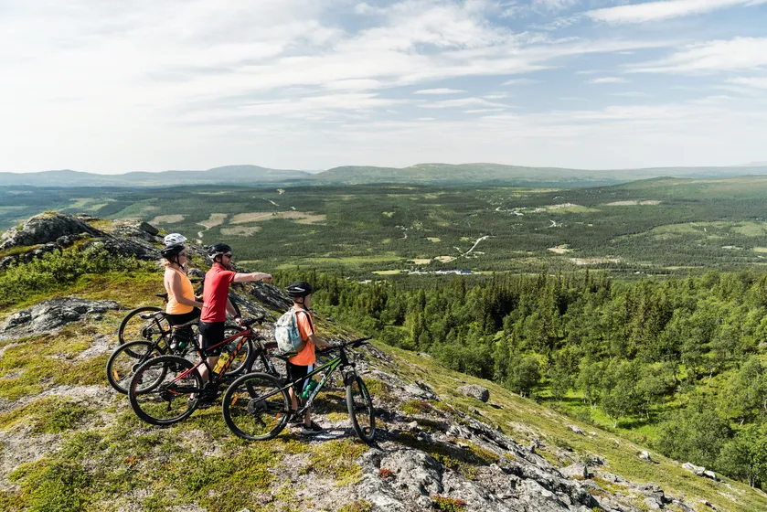 Familj blickar ut på fjällen på sina mtb-cyklar