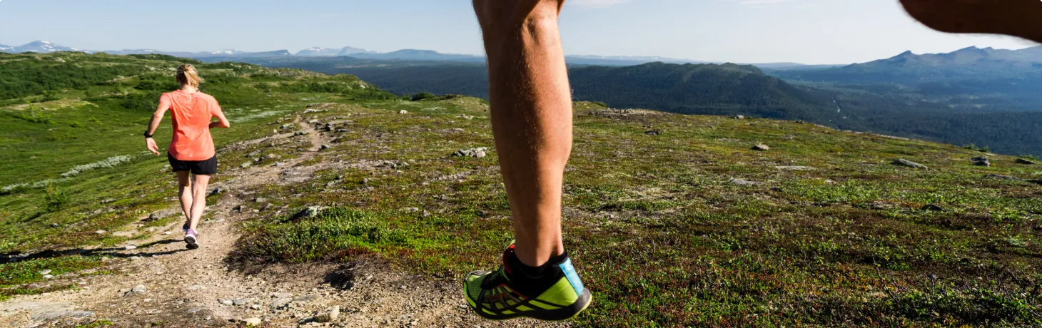 Två personer springer trailrunning på fjället