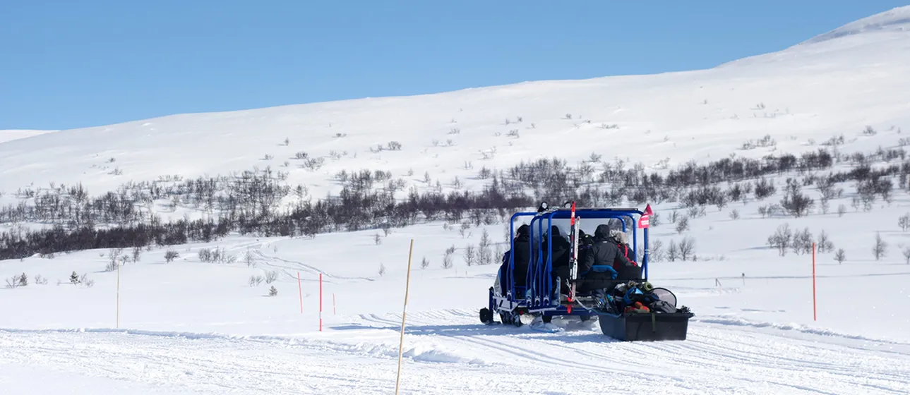 Två personer åker snövessla mot Andersborg