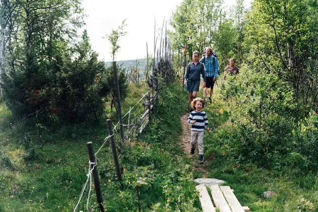 En familj är ute och fjällvandrar med sitt barn