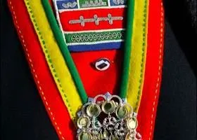 Detalj från samisk dräkt, i rött, gult, grönt och blått. Med silverdetaljer.