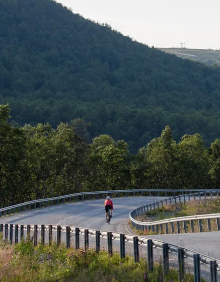 Person som cyklar landsväg i fjälldalgång