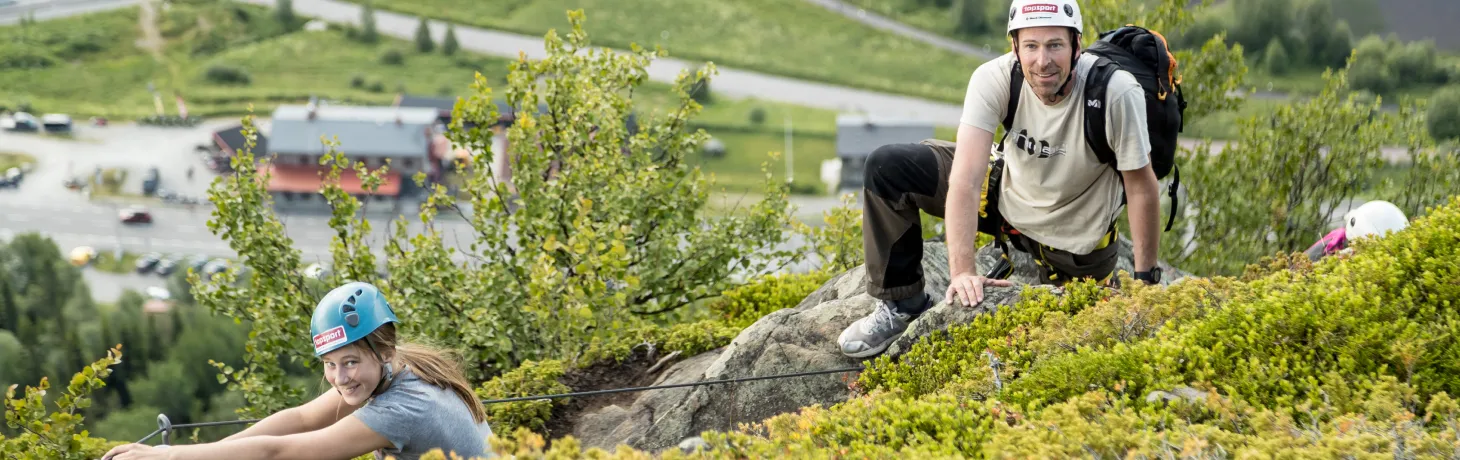 Två personer klättrar vi ferrata på funäsdalsberget