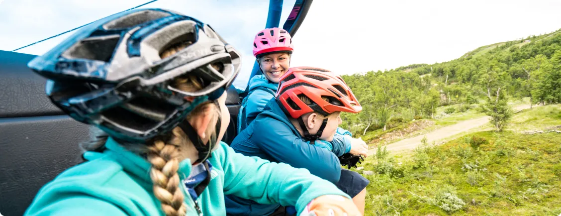 Familj åker lift upp på fjället med mtb