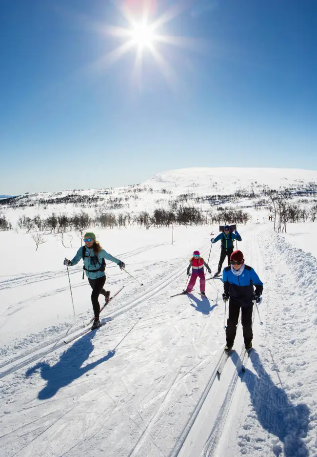 Familj åker längskidor på fjället