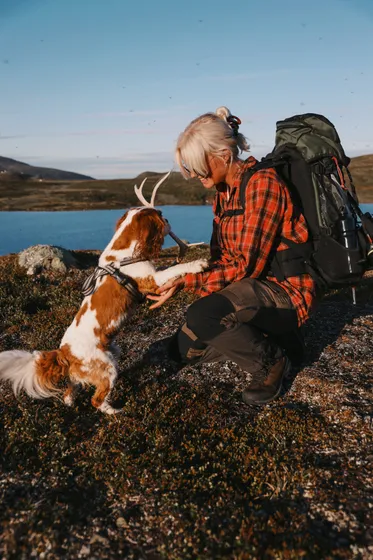 Kvinna leker med sin hund på en vandring