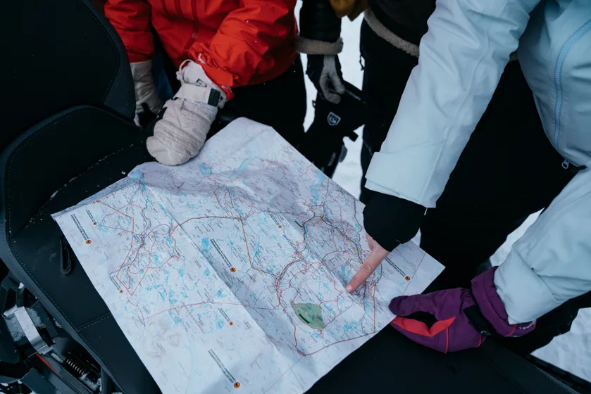 Personer pekar på en karta med skoterleder