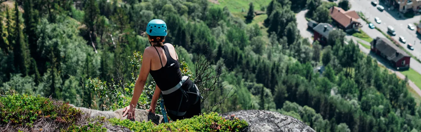 Kvinna klättrar via ferrata i Funäsfjällen