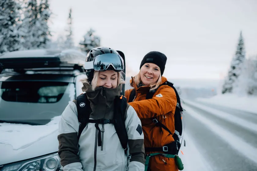 Två personer packar sin väska i vinterlandskap