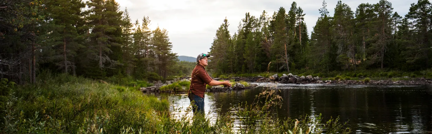 Man fiskar vid en rinnande å