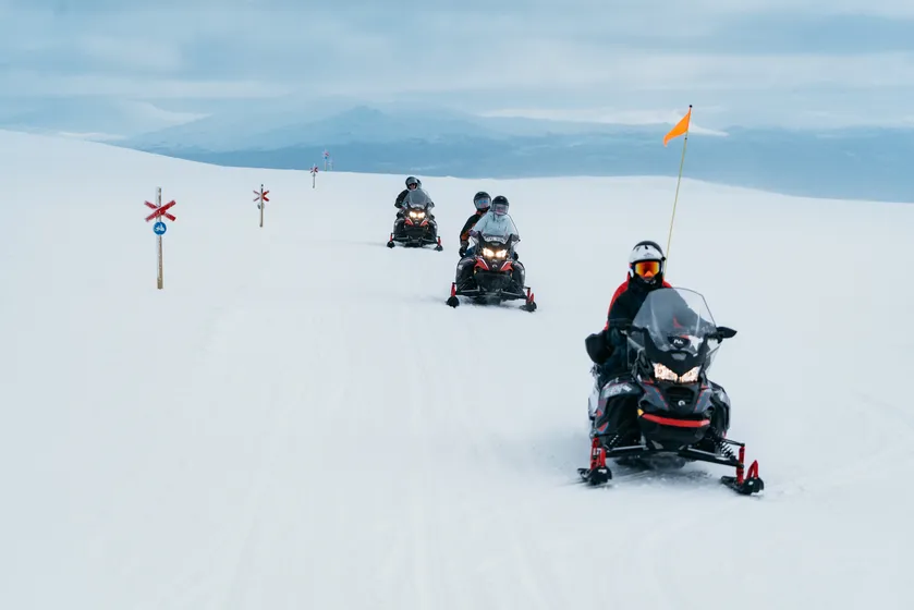 Skotrar åker på fjället med guide