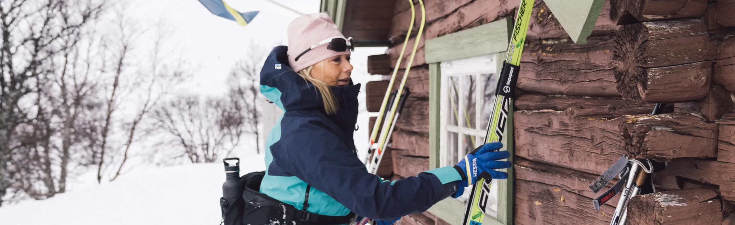 Kvinna åker plockar upp sina skidor i vintermiljö